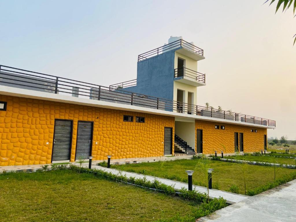 a yellow building with a balcony on top of it at New Corbett Hotel and Resort in Belparāo