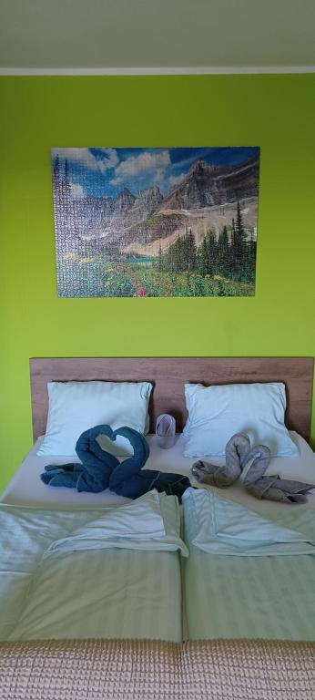 two stuffed animals sitting on a bed with a painting at Apartmán Kováčová - The Apartment in spa village in Kováčová