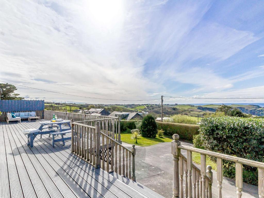 a wooden deck with a table and a bench on it at 4 Bed in Tintagel 75335 in Forrabury