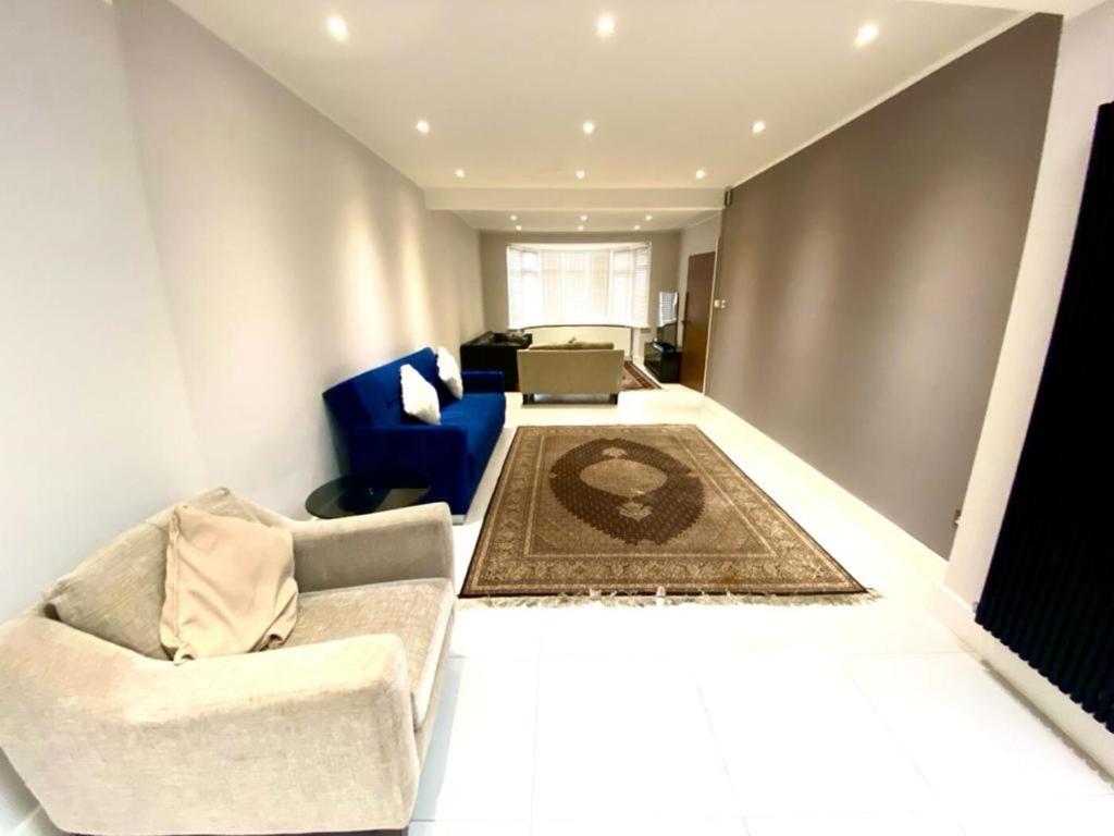 sala de estar con sofá y silla en Luxury 5 bedroom house with Private car park in London, en Hendon