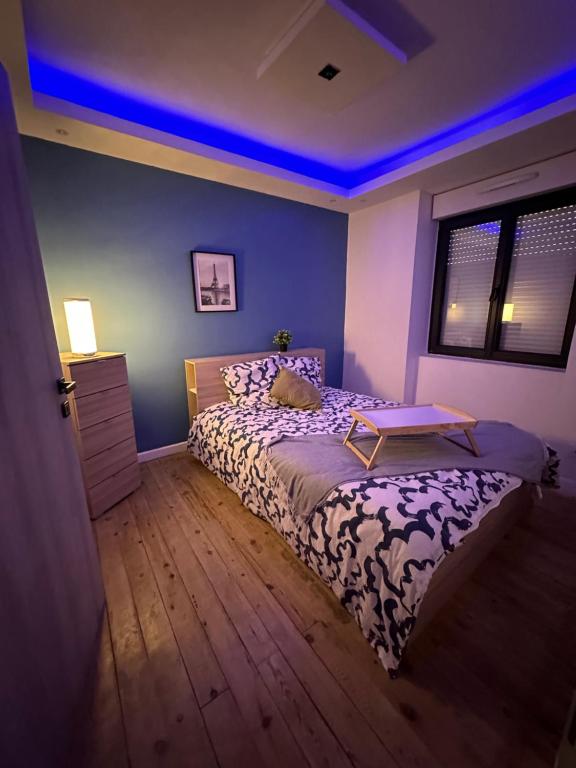 ein Schlafzimmer mit einem Bett und einem blauen Licht in der Unterkunft Maison de vacances in Maisdon-sur-Sèvre