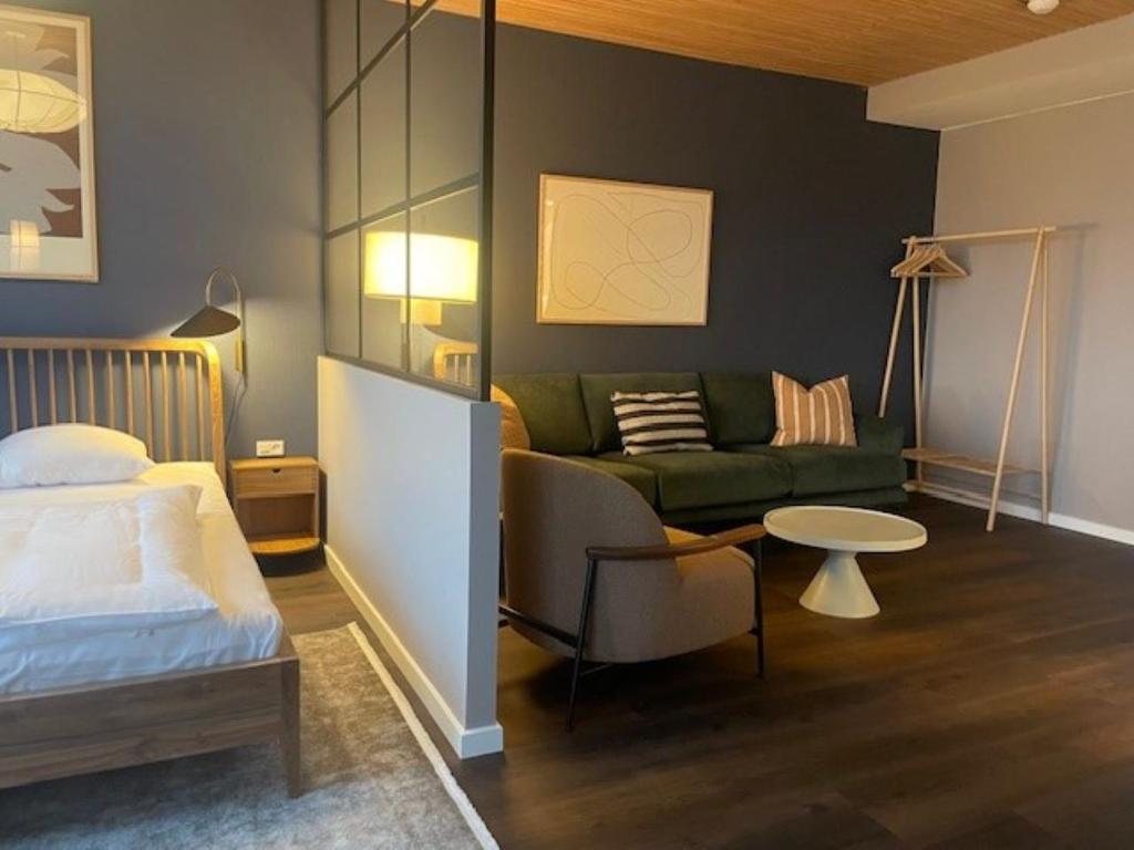 een slaapkamer met een bed, een bank en een tafel bij Apartments by Jutlandia in Frederikshavn