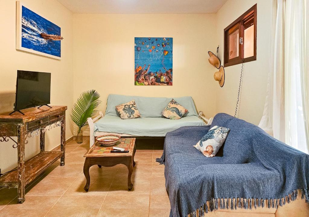 a living room with a couch and a tv at Casa Pipa Beleza in Pipa