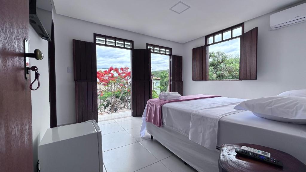 a bedroom with a bed and a window with a view at Pousada Estrelar in Lençóis
