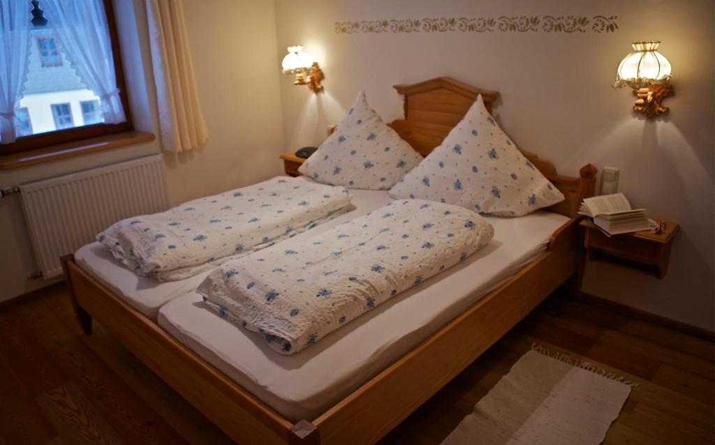 a bedroom with a bed with two pillows on it at Dandl-Hof in Ruhpolding