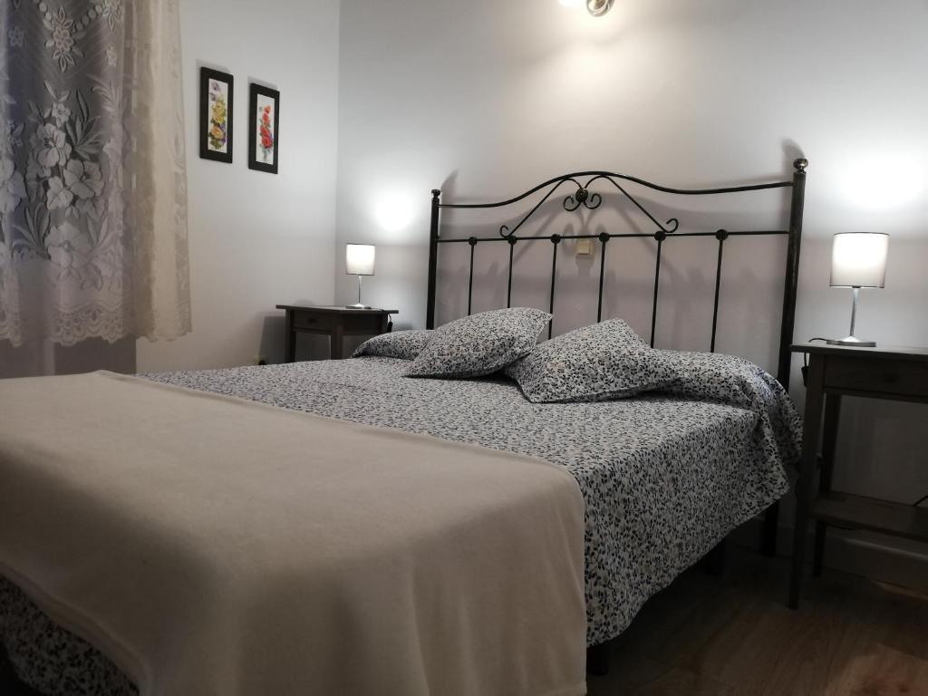 1 dormitorio con 1 cama con manta y almohadas en AT Villa Manola, en Colombres