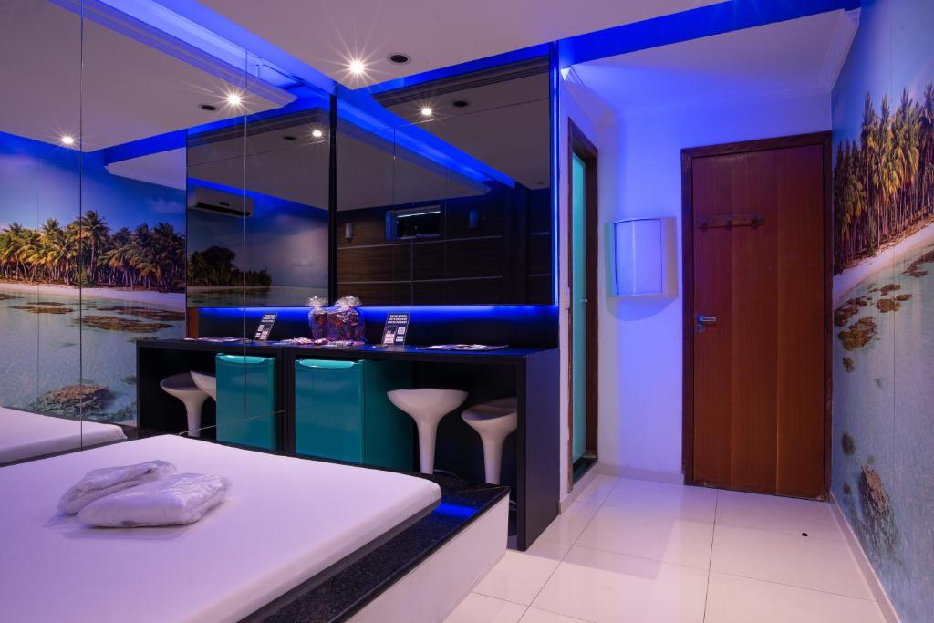 a bathroom with a bar with blue lighting at Motel Fantasy 2 (Adult Only) in Contagem