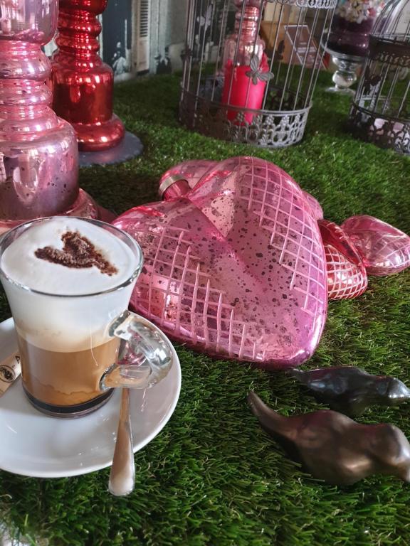 a cup of coffee on a plate on the grass at Hôtel du Cygne in Bevaix