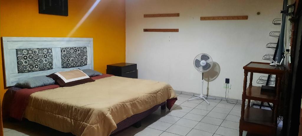 1 dormitorio con 1 cama y ventilador en Casa AMPLIA en excelente UBICACIÓN!, en Santa Julia