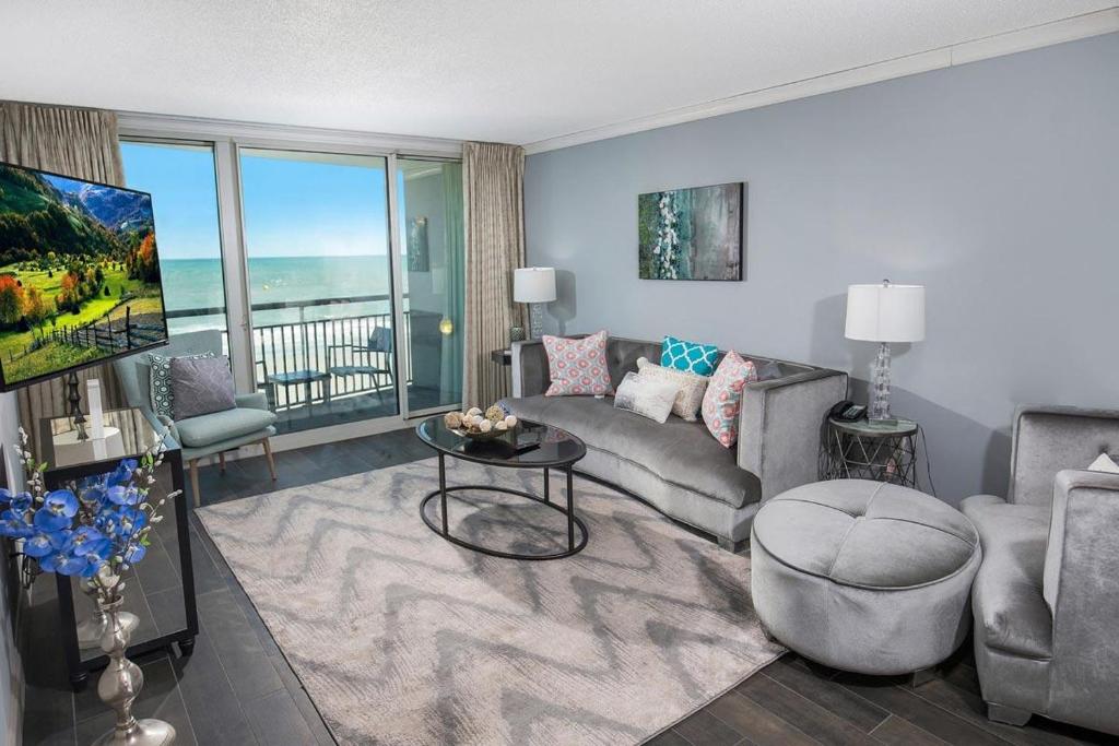 默特爾海灘的住宿－Myrtle Beach Getaway 3BR Condo with Panoramic Ocean Views，客厅配有沙发和桌子