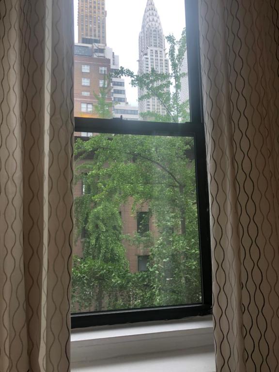 a window with a view of a city at Cozy place in midtown NYC in New York
