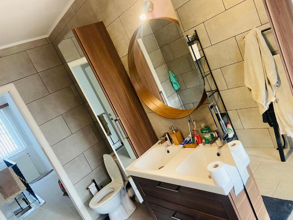 uma casa de banho com um lavatório, um espelho e um WC. em Villa luxe 