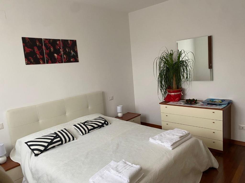 1 dormitorio con 1 cama y vestidor con espejo en Bella Ciao Airport Apartment, en Seriate