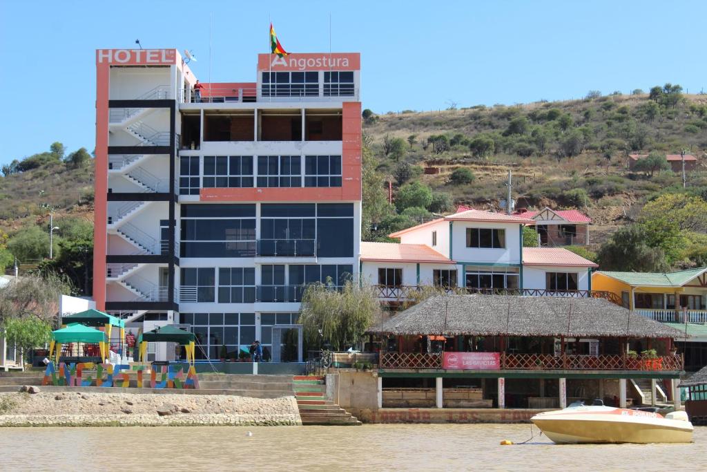 ein Hotel auf dem Wasser mit einem Boot davor in der Unterkunft Hotel Angostura in Cochabamba