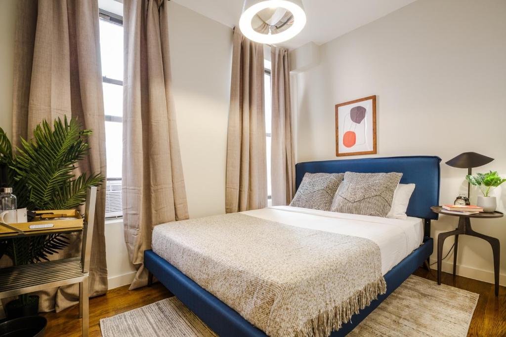 a bedroom with a blue bed and a window at Apartment 235: Lower East Side in New York