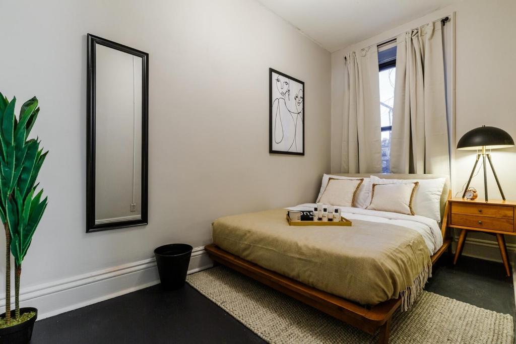 - une chambre avec un lit, une table et un miroir dans l'établissement Apartment 332: Hells Kitchen, à New York