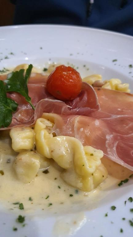 a plate of food with meat and pasta on it at Hôtel du Cygne in Bevaix