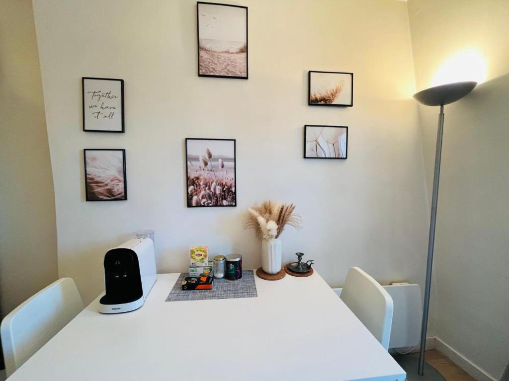 a white table with a lamp and pictures on the wall at Dream Dwell Paris-Charming Studio superb location in 7th district Paris in Paris