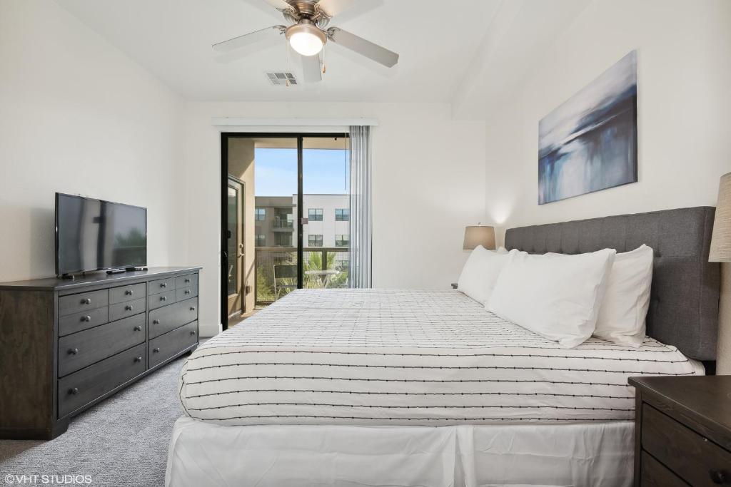 um quarto branco com uma cama e uma televisão em PURE SUITES 2 BED DOWNTOWN PHOENIX POOL GYM em Phoenix