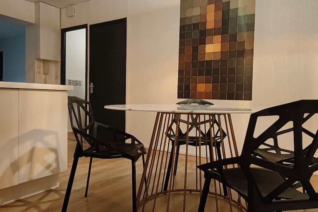 une cuisine avec une table et deux chaises noires dans l'établissement Mona Lisa, à Sallaumines