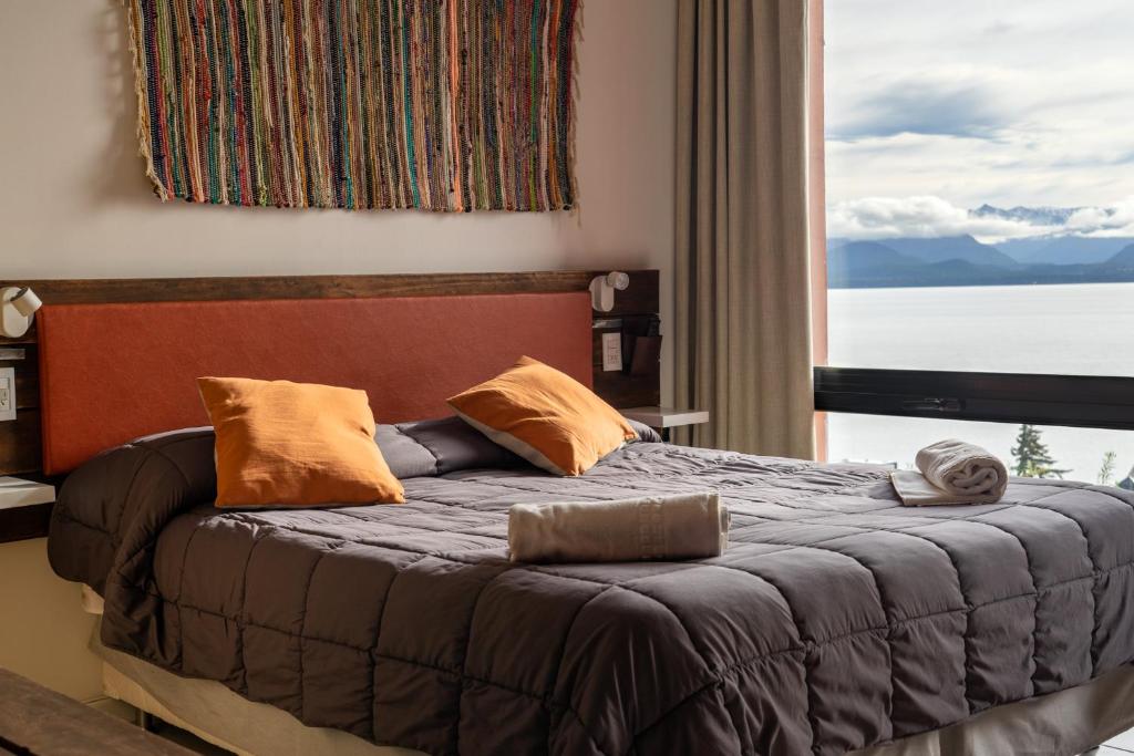 a bedroom with a bed with a large window at Belgrano Decks II in San Carlos de Bariloche