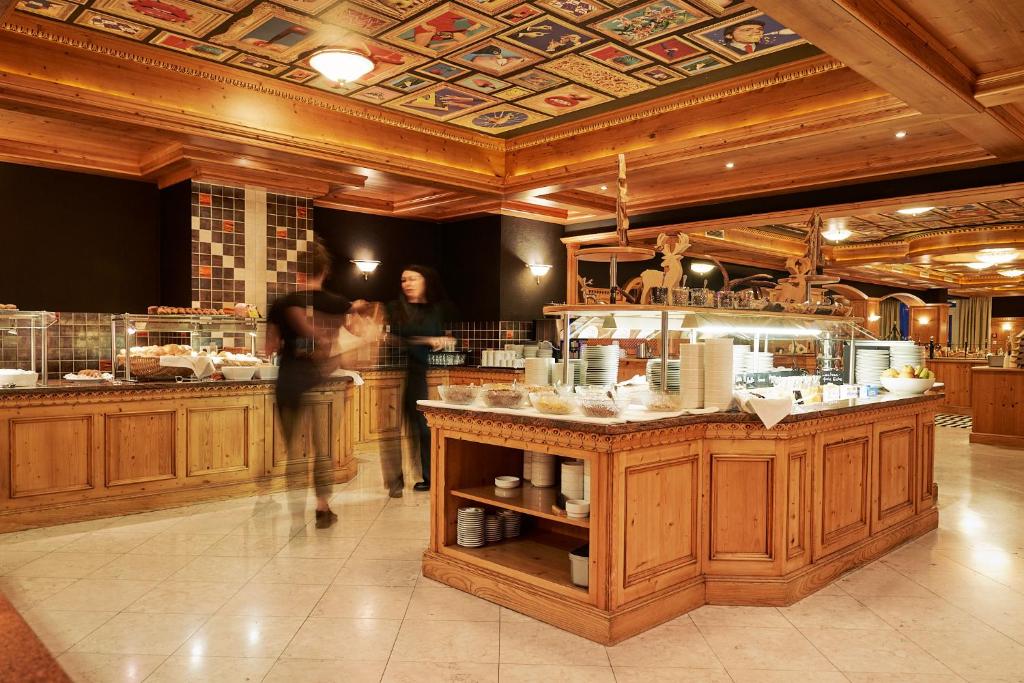 a woman walking in a kitchen with a counter at carpe solem KAPOOM incl Zell am See-Kaprun Summer Card in Kaprun