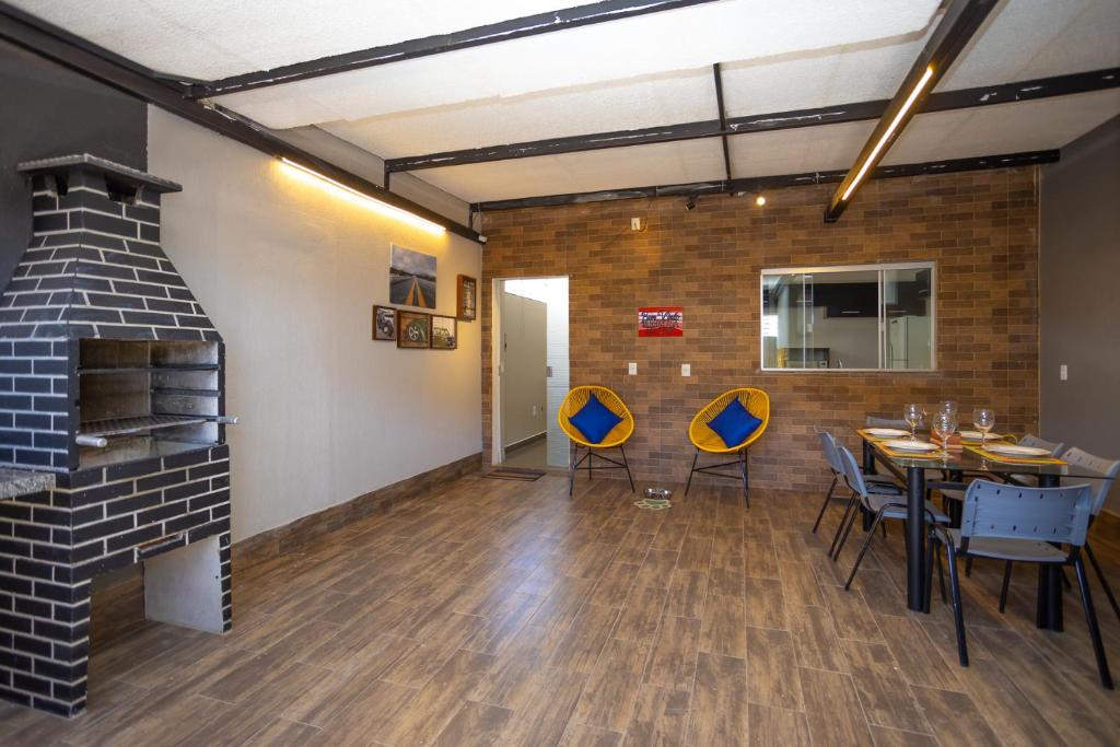 a dining room with a fireplace and a table and chairs at Botanical House, bairro Jardim Botânico 3 de Bsb in Brasilia