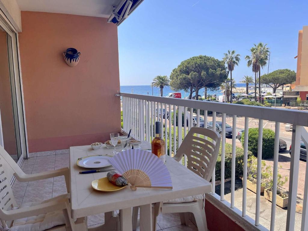 une table blanche et des chaises sur un balcon avec l'océan dans l'établissement Appartement 2 pièces proche plage avec garage, Fréjus - FR-1-226A-167, à Fréjus