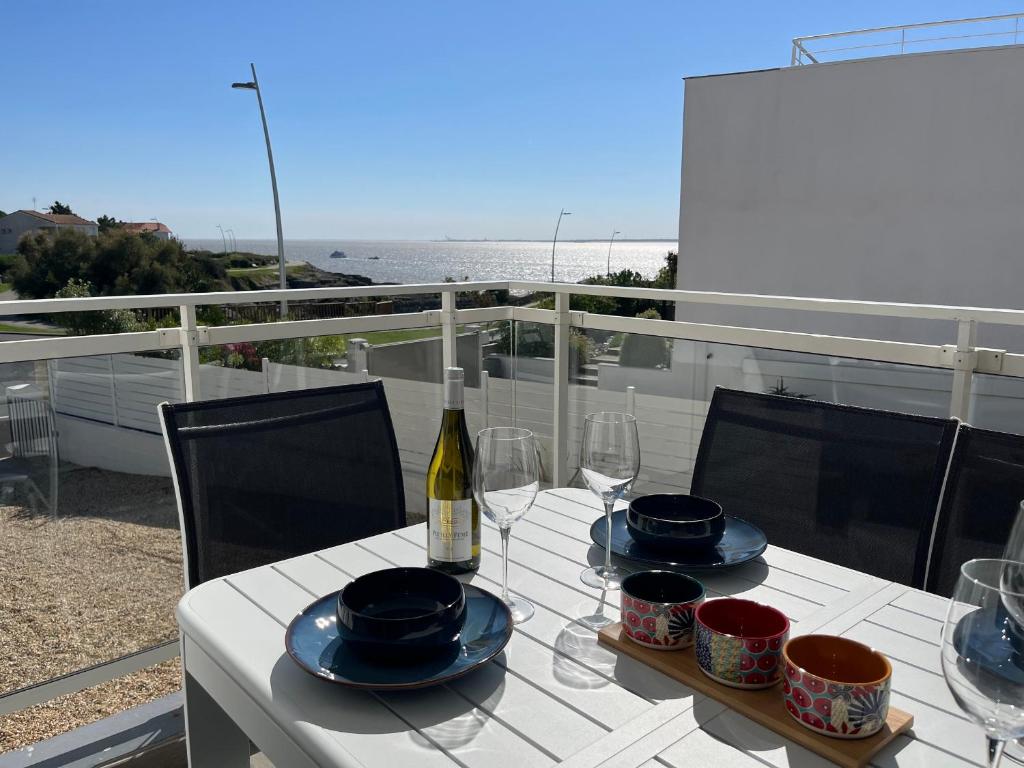 - une table avec une bouteille de vin et des verres sur un balcon dans l'établissement Appartement Vaux-sur-Mer, 4 pièces, 6 personnes - FR-1-539-57, à Vaux-sur-Mer