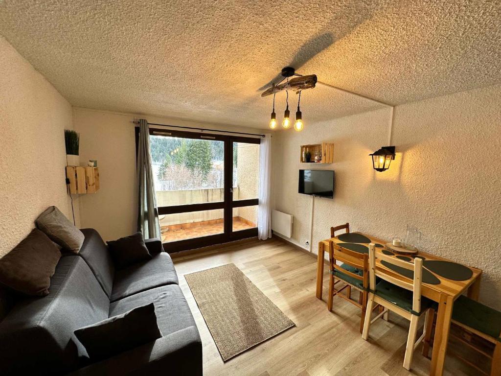 a living room with a couch and a table at Studio Corrençon-en-Vercors, 1 pièce, 4 personnes - FR-1-515-204 in Corrençon-en-Vercors