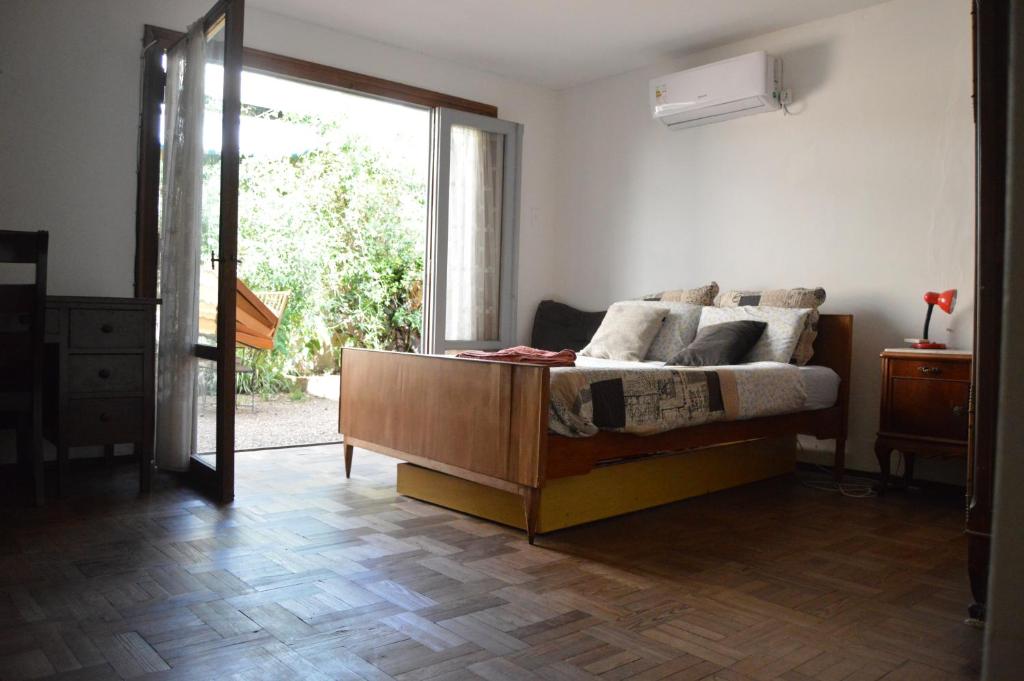 a living room with a bed and a large window at 3B Habitación SUR con baño privado y AC in Salto