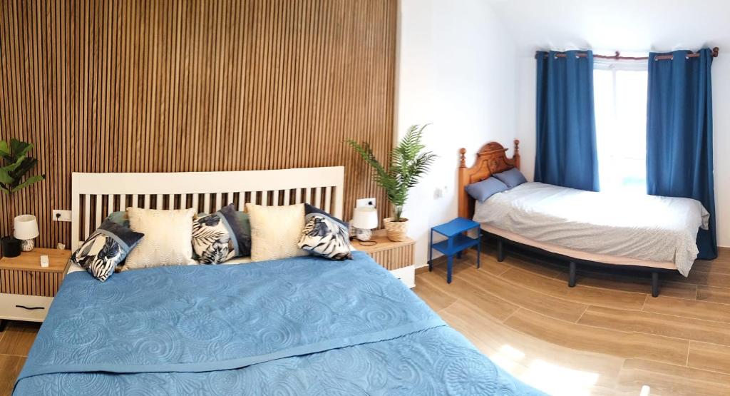 a bedroom with a bed with blue sheets and pillows at Casa MACON BLUE in Caleta De Fuste