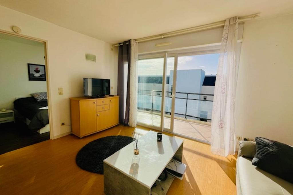 sala de estar con sofá y ventana grande en Charming love nest with balcony en La Rochelle