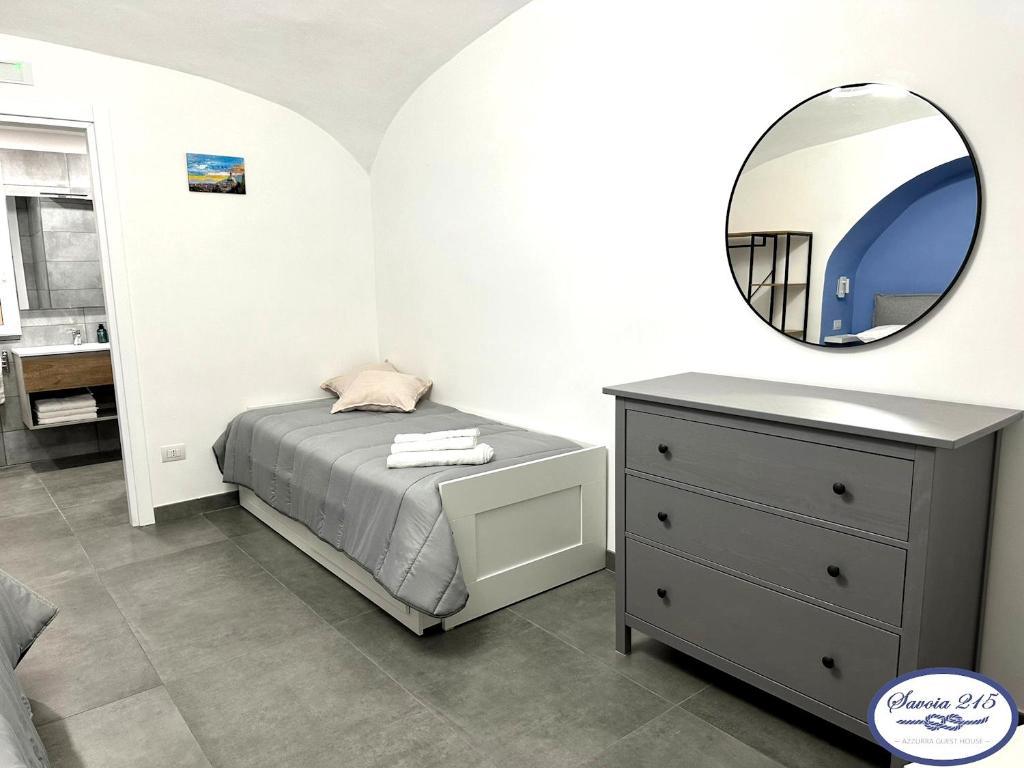 a bedroom with a bed and a mirror and a dresser at Savoia 215 - Azzurra Guest House - Napoli in Naples
