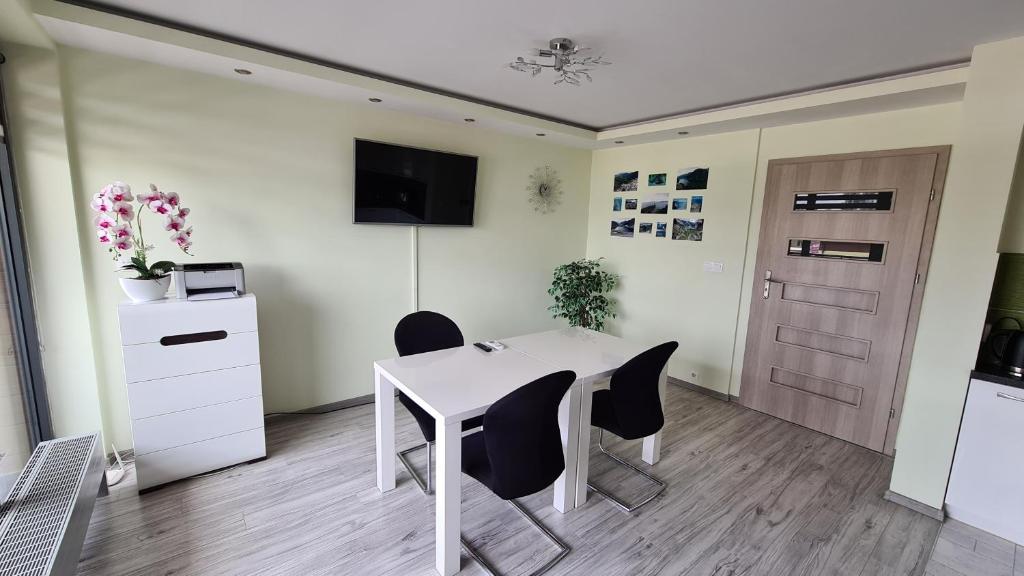an office with a white table and chairs and a door at Comfy Studio in Rzeszów