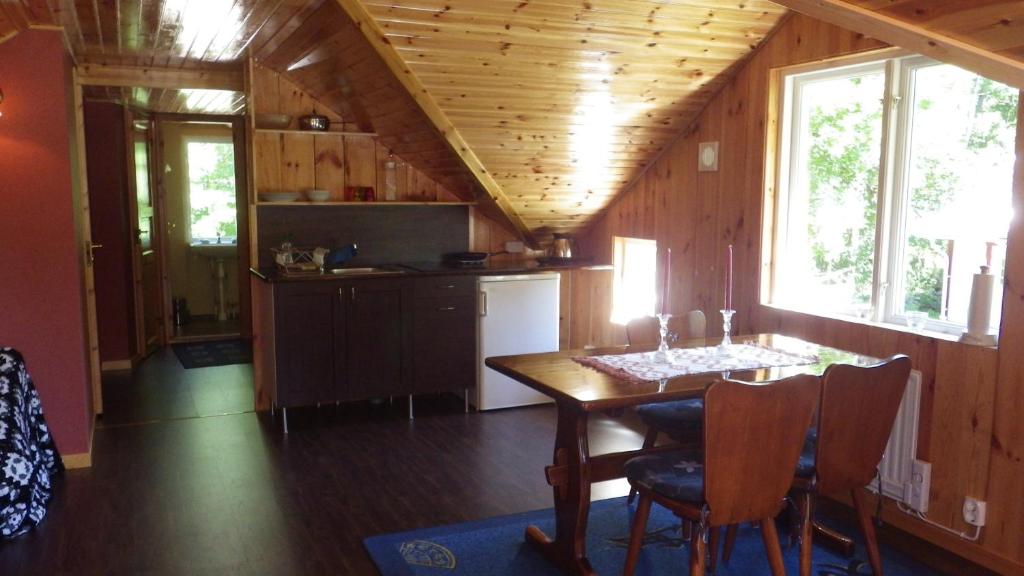 una cucina e una sala da pranzo con tavolo in una cabina di Gästvåning i Hajstorp a Töreboda