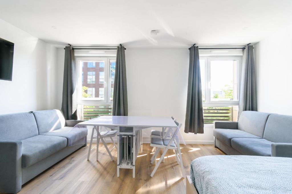 un salon avec un canapé et une table dans l'établissement Studio Disneyland RER 6 pers, à Montévrain