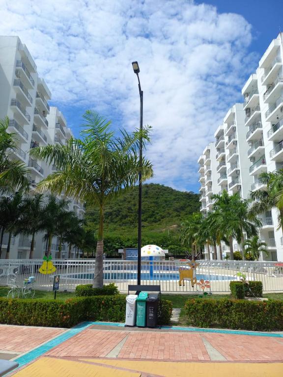 a street light and palm trees in front of buildings at Beatiful apartment in condo in Girardot