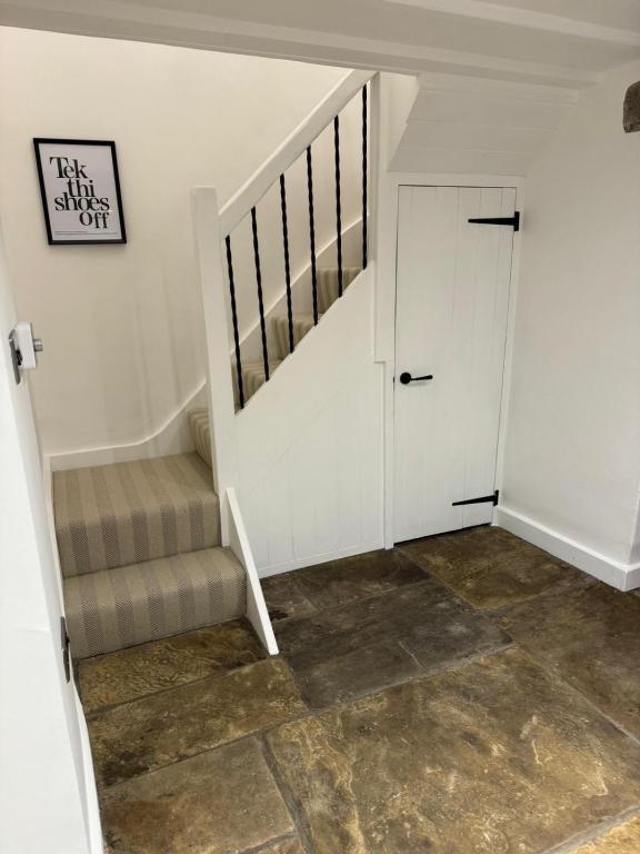 a stairway with a white door and a staircase with aige carpet at Lyndale in Taxal