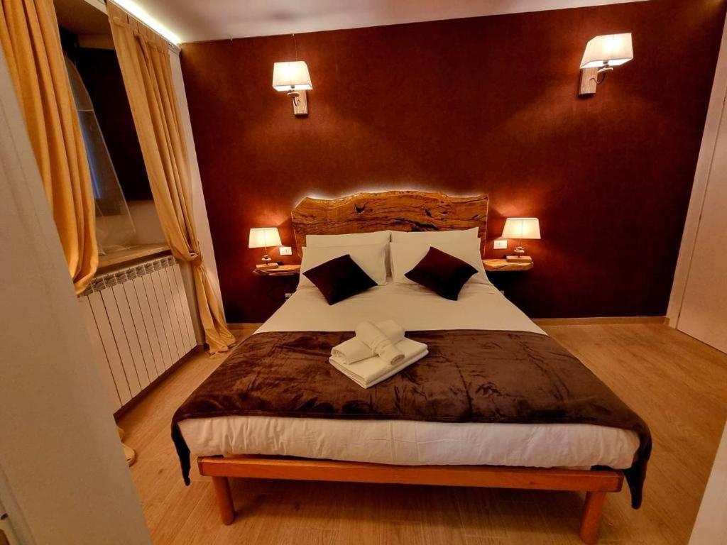 um quarto com uma cama grande e 2 almofadas em Dimora Grotta Masciarelli em LʼAquila