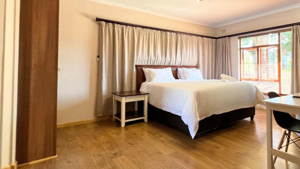 a bedroom with a large bed and a window at Kabana Family Home and Guest House in Cape Town