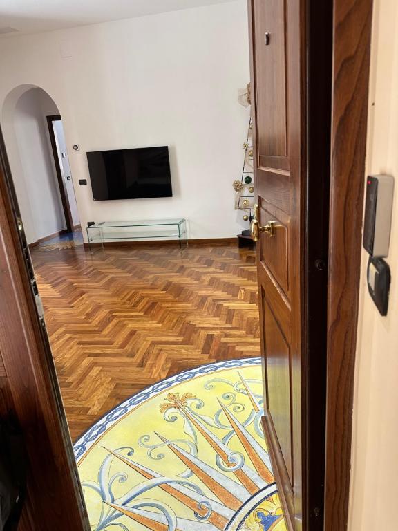 uma porta aberta para um quarto com uma televisão e um tapete em Francy's house em Salerno