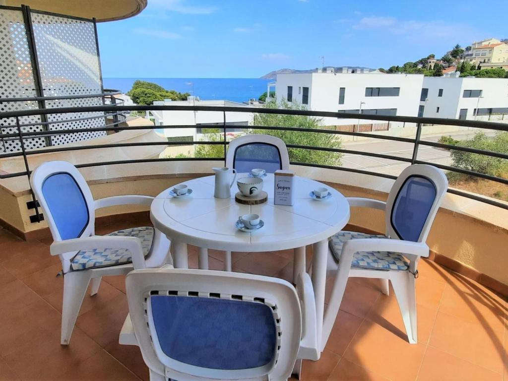 - Balcón con mesa blanca y sillas en Apartamento Llançà, 2 dormitorios, 4 personas - ES-170-48, en Llançà