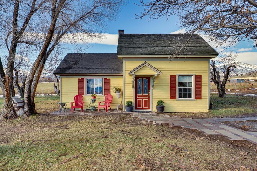 une maison jaune avec des chaises rouges devant elle dans l'établissement Pet-Friendly Utah Abode with Patio, Fire Pit and Yard!, 