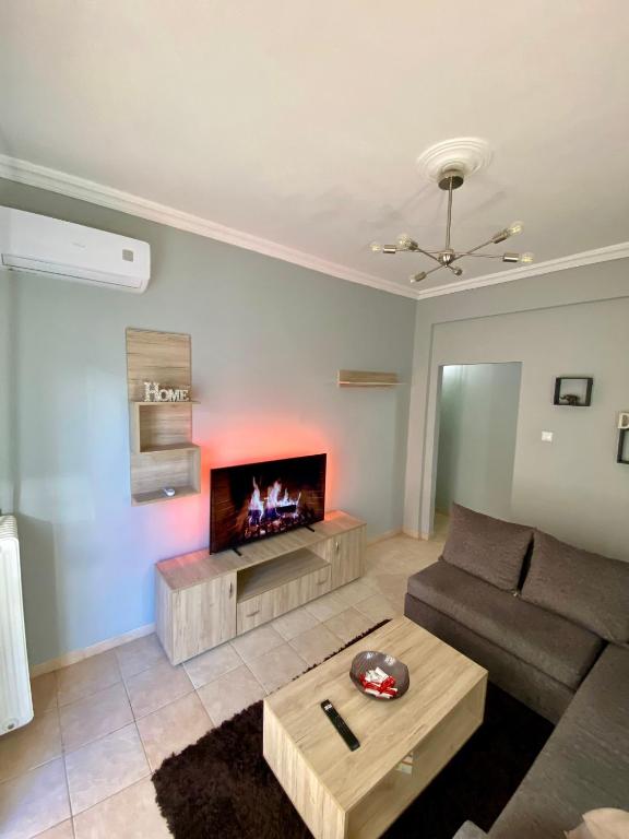 sala de estar con sofá y chimenea en Cozy flat Korydallos, en Pireo