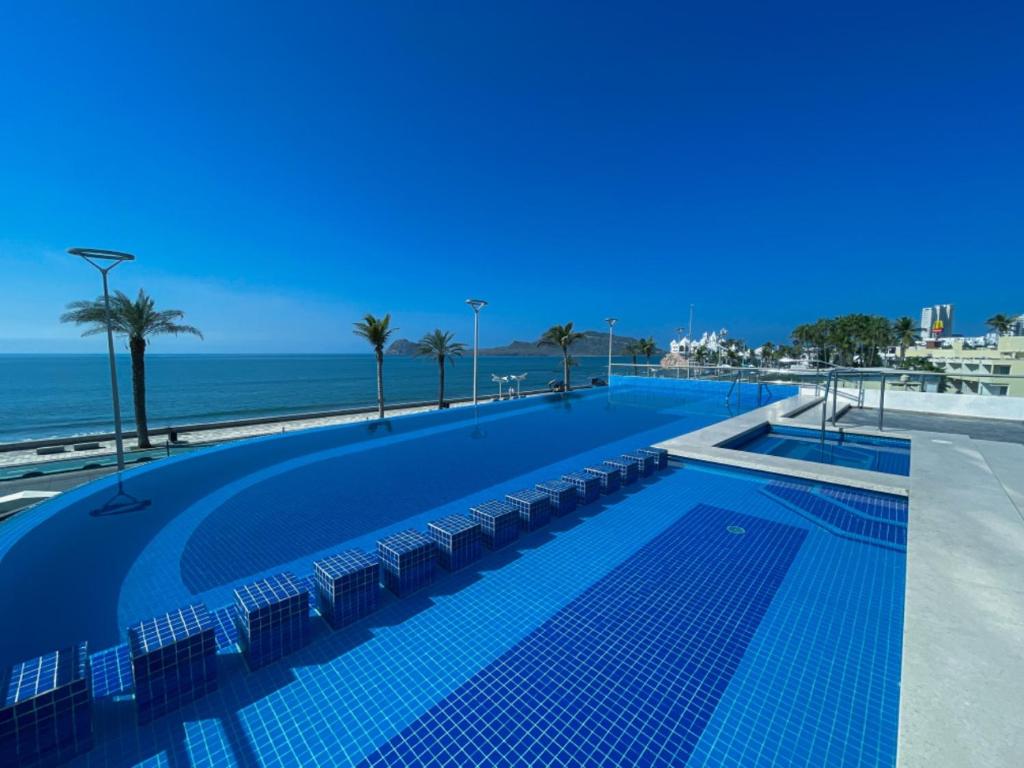 uma grande piscina junto à praia em Varali Grand Hotel em Mazatlán