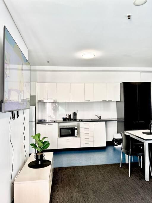 una cocina con armarios blancos y una mesa con una planta en entire 2BR Central Apt 1004, en Adelaida