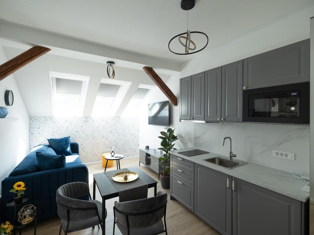 a kitchen and living room with a blue couch at Zagreb City Center Apartments LUX in Zagreb