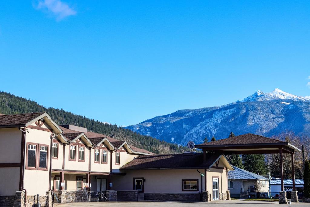 a row of buildings with mountains in the background at Northwinds Hotel Revelstoke in Revelstoke
