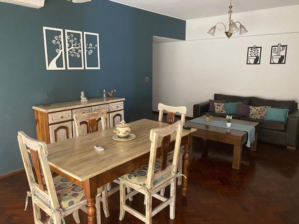 een woonkamer met een houten tafel en een bank bij Alquiler cálido departamento en el corazon mendocino in Mendoza